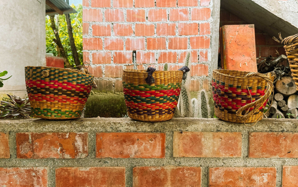 Three colourful woven baskets on a brick wall at Madre Térra, Peru
