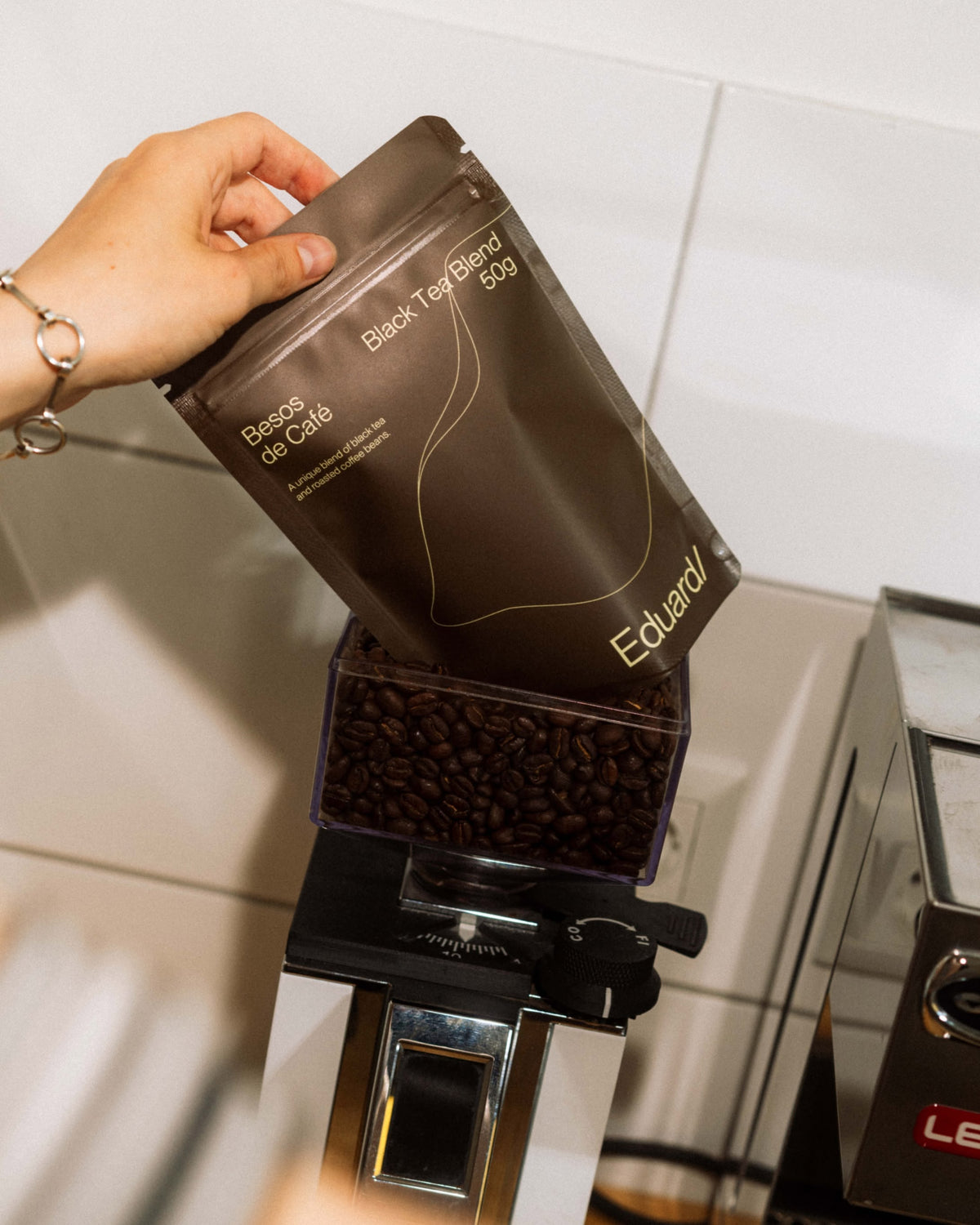 Beutel Besos de Café neben einer Kaffeemühle