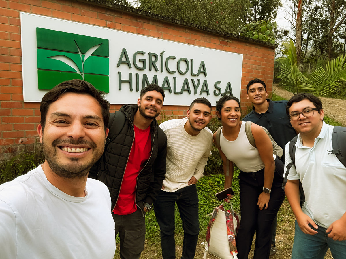 Eduardo with the team in front of the Agrícola Himalaya sign in Colombia