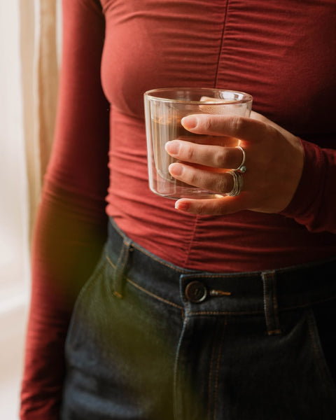 Person holding a glass of tea
