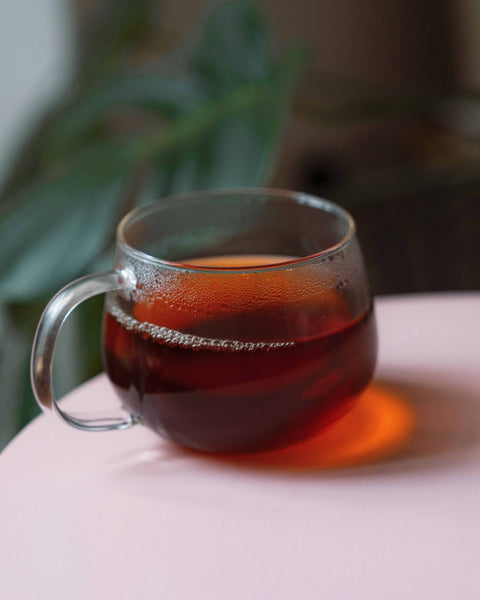 Dark infusion of Himalaya Imperial Black in a glass cup